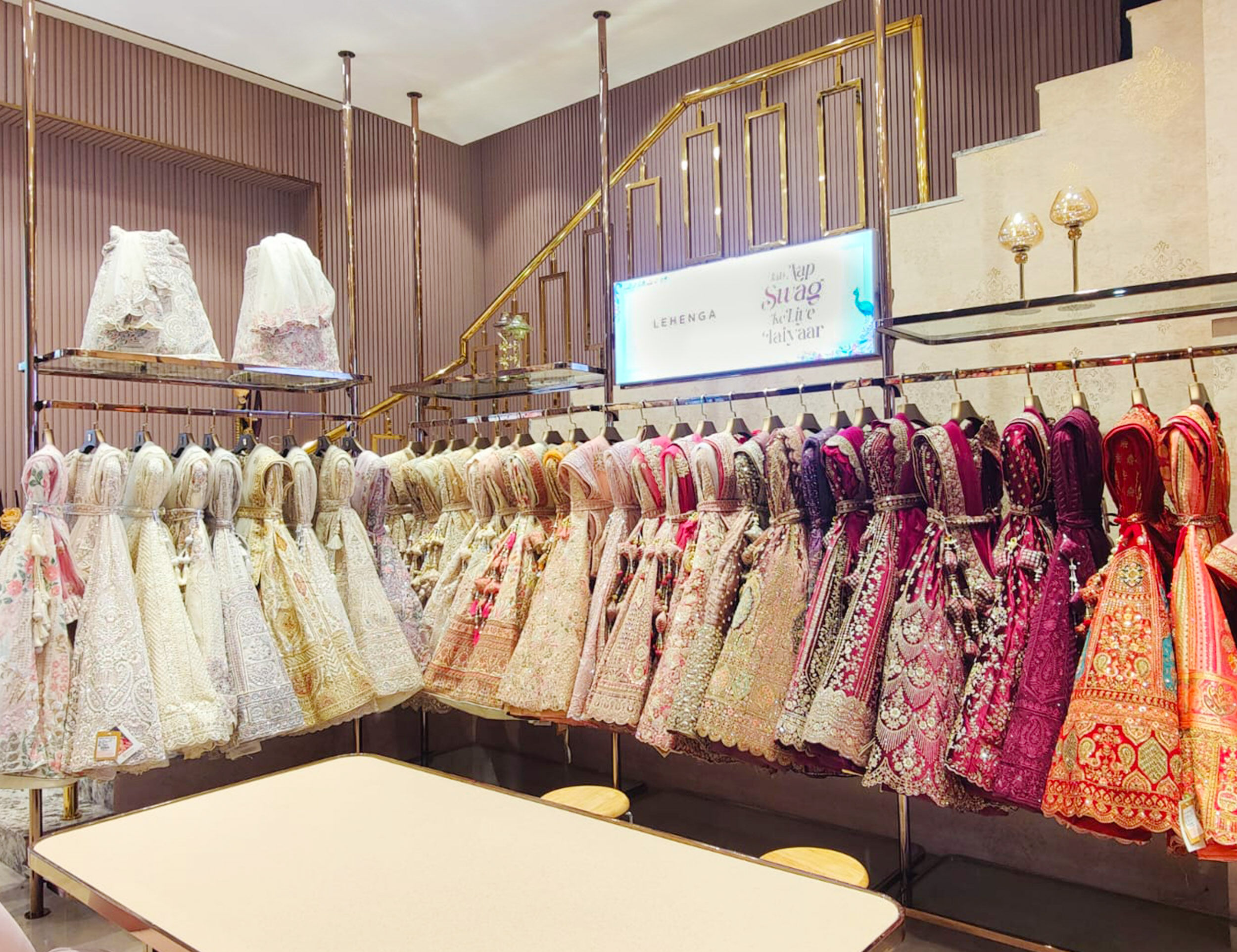 A stunning collection of colorful lehengas available in a wedding dress store.